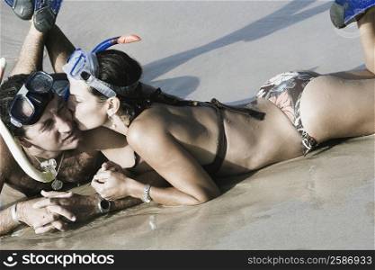 Mid adult woman kissing to a mid adult man on the beach