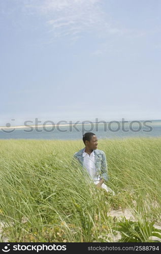 Mid adult woman kneeling on grass