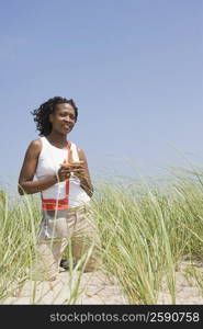 Mid adult woman kneeling on the beach and holding starfish