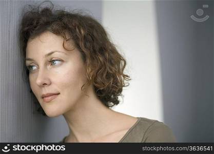 Mid adult woman leans against wall