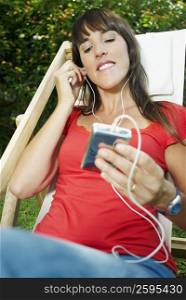 Mid adult woman listening to an mp3 player