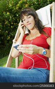 Mid adult woman listening to an mp3 player