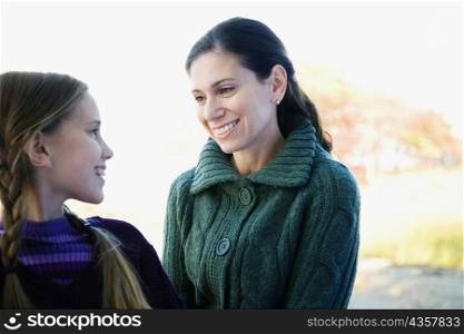 Mid adult woman looking at her daughter and smiling