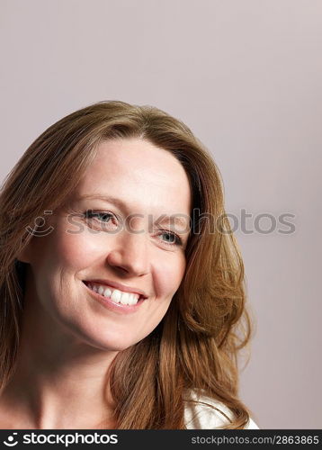 Mid-adult woman looking away and smiling close-up