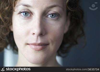 Mid adult woman looks directly at camera