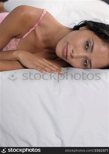 Mid-adult woman lying down on bed, head and shoulders