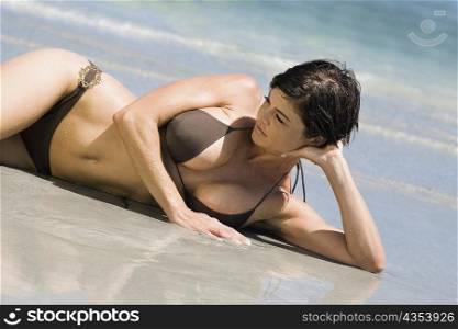 Mid adult woman lying on the beach
