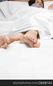 Mid adult woman lying on the bed and smiling