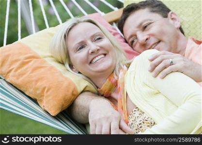 Mid adult woman lying with a mature man in a hammock