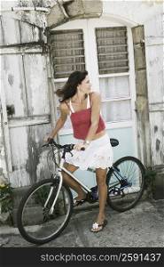 Mid adult woman riding a bicycle and looking over her shoulder