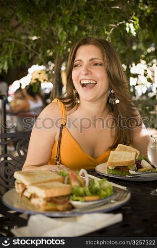 Mid adult woman sitting at a restaurant and laughing, Santo Domingo, Dominican Republic