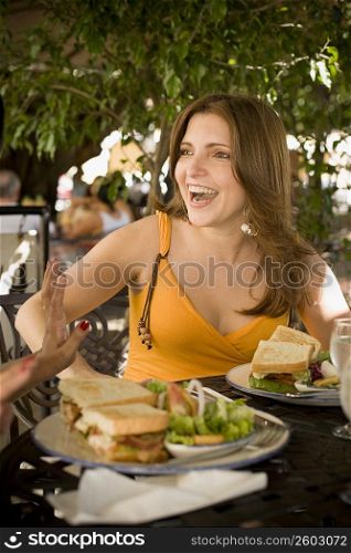 Mid adult woman sitting in a restaurant and laughing, Santo Domingo, Dominican Republic