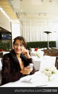 Mid adult woman sitting in a restaurant and smiling