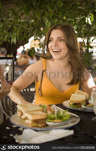 Mid adult woman sitting in a restaurant and smiling, Santo Domingo, Dominican Republic