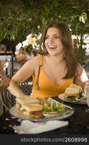 Mid adult woman sitting in a restaurant and smiling, Santo Domingo, Dominican Republic