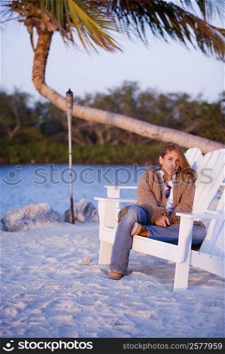 Mid adult woman sitting on a lounge chair