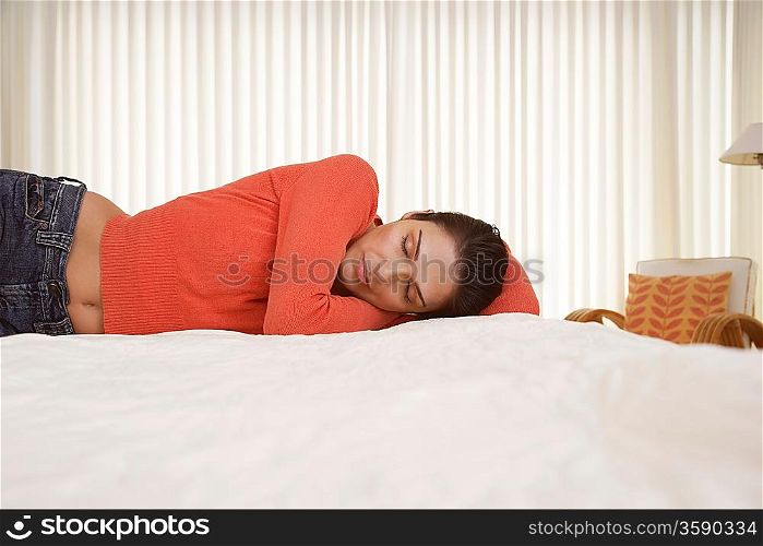 Mid-adult woman sleeping on bed