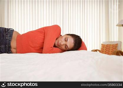 Mid-adult woman sleeping on bed