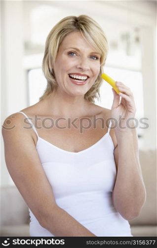 Mid Adult Woman Smiling At Camera And Eating Pineapple