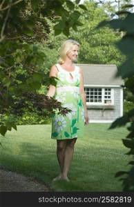 Mid adult woman standing in a lawn and smiling