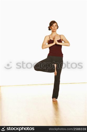 Mid adult woman standing in a tree pose