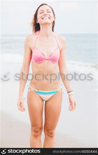 Mid adult woman standing on beach,smiling