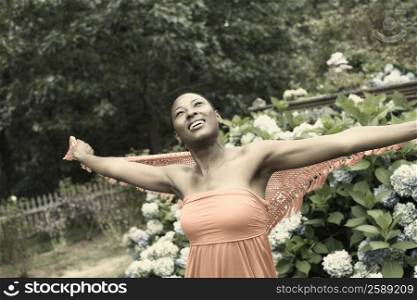 Mid adult woman standing with her arms outstretched and smiling
