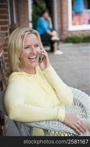 Mid adult woman talking on a mobile phone and laughing