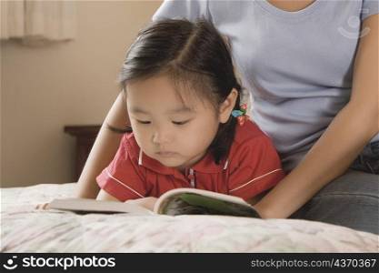 Mid adult woman teaching her daughter