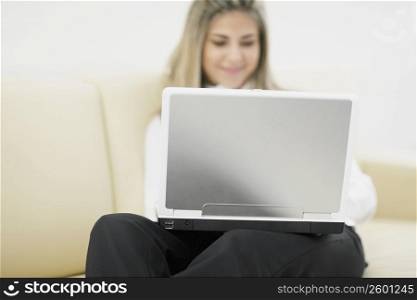 Mid adult woman using a laptop and smiling