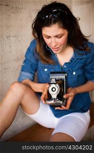 Mid adult woman using vintage medium format camera