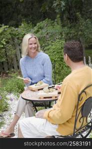 Mid adult woman with a mature man having lunch in a garden
