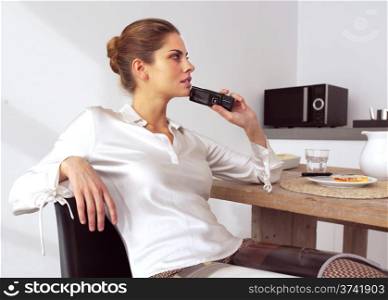 mid adult woman with her mobile phone in kitchen