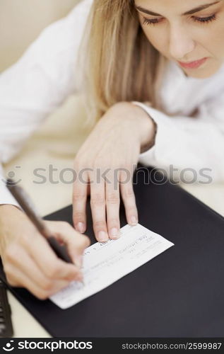 Mid adult woman writing on a sheet of paper