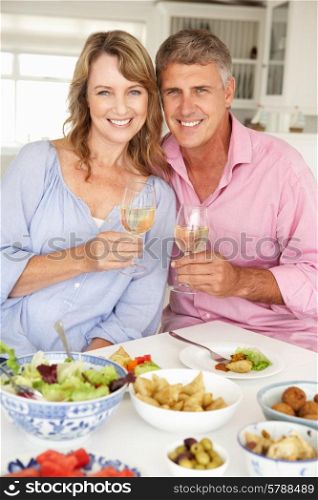 Mid age couple enjoying meal at home