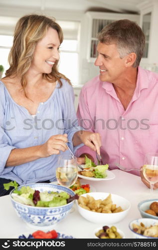 Mid age couple enjoying meal at home