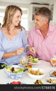 Mid age couple enjoying meal at home