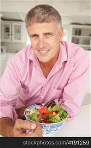 Mid age man eating salad