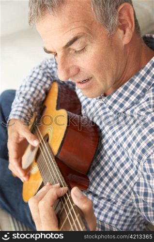 Mid age man playing acoustic guitar