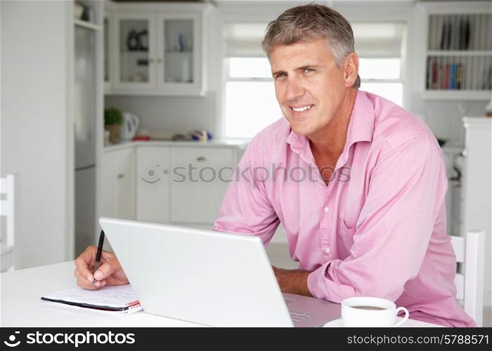 Mid age man working on laptop at home