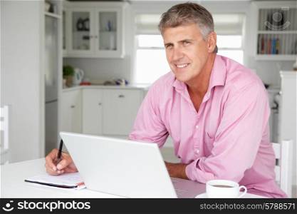 Mid age man working on laptop at home
