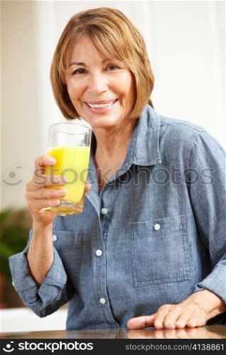 Mid age woman drinking orange juice