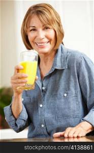 Mid age woman drinking orange juice
