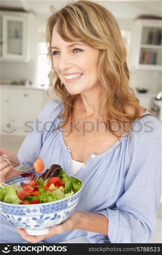 Mid age woman eating salad