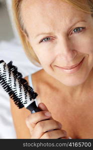 Mid age woman holding hairbrush