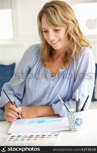 Mid age woman painting with watercolors