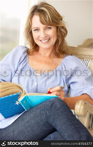 Mid age woman writing in notebook