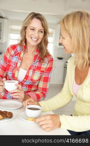 Mid age women chatting over coffee at home