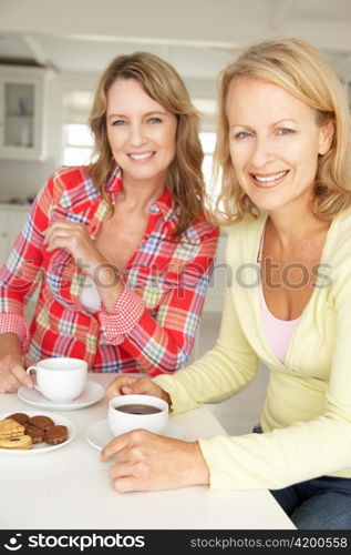 Mid age women chatting over coffee at home