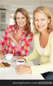 Mid age women chatting over coffee at home